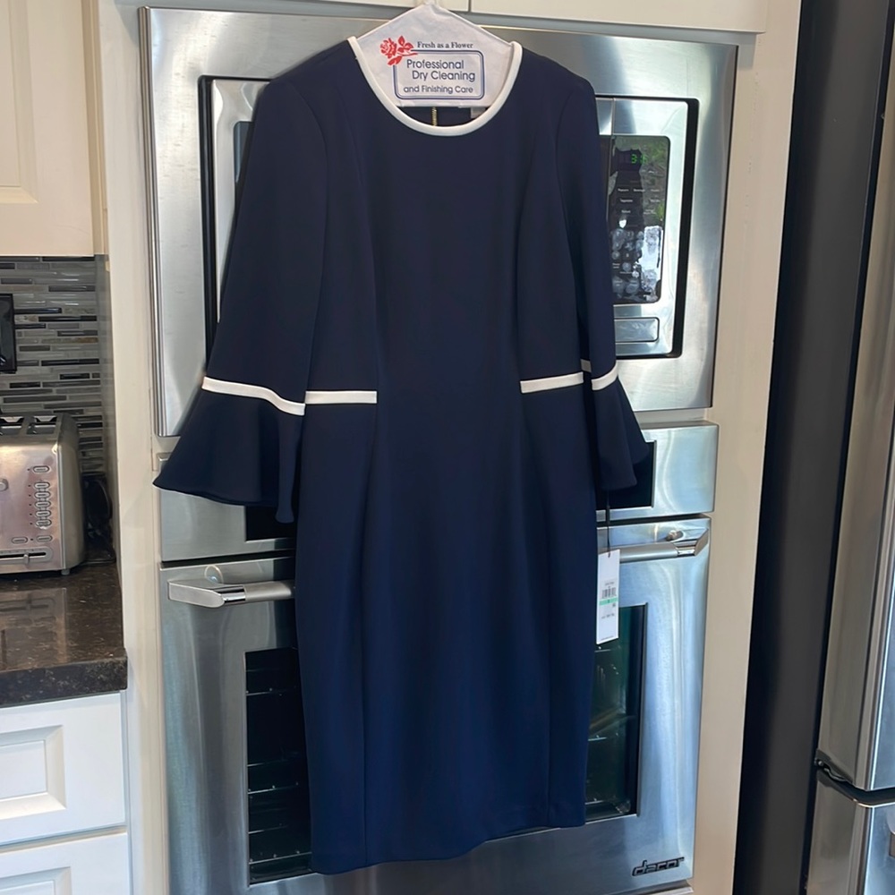 Calvin Klein never been worn classic, stunning black dress with white piping.